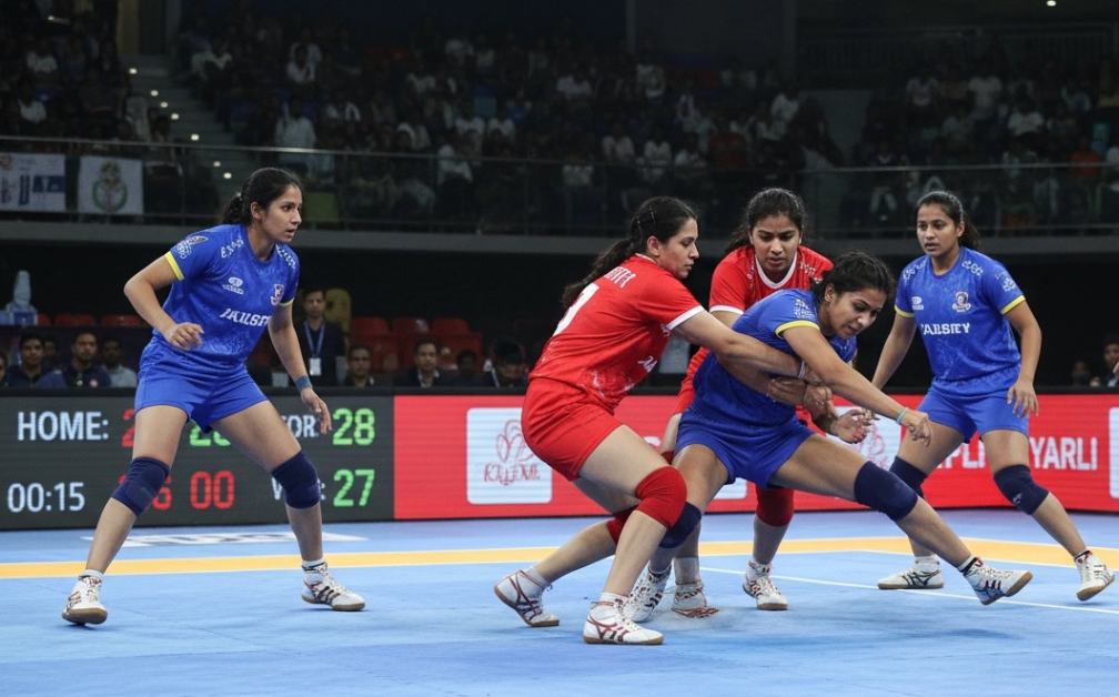 players hold off an opponent in a kabaddi match